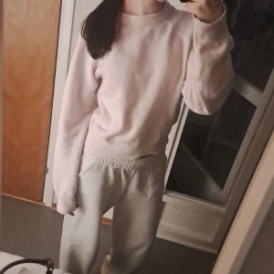 Ljusrosa stickad tröja - Mysig ljusrosa stickad tröja med rund hals och långa ärmar. Perfekt för kyliga dagar och ger en avslappnad look. Passar bra till både jeans och mjukisbyxor.