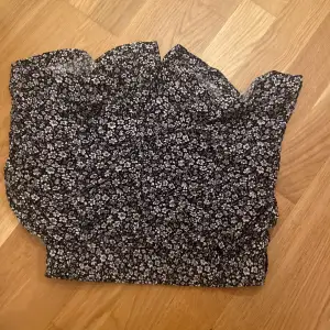 Säljer en söt blommig topp från Amisu i svart och vitt. Shortsen har en offshoulder-design och är perfekt för både vardag och fest. Den är tillverkad i ett lätt och bekvämt material.