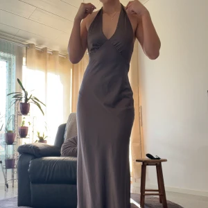 Brun långklänning med knytband - Brun balklänning från pepparmayo! Super fin med knytningar både vid nacken och ryggen vilket gör det justerbar. Köpt för 1,3, säljer för 800🫶🏼🫶🏼