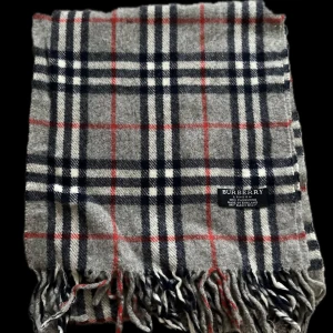 Burberry Halsduk - En klassisk burberry halsduk med stilrent mönster. Från 1999-2000 talet. Mitt pris är 200kr. Skriv i dm innan köp!
