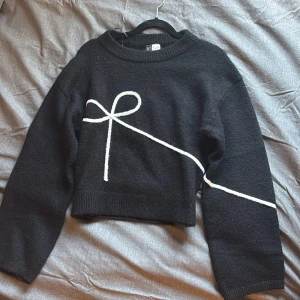 Svart kofta med rosett  - Svart kofta från H&M med en vit söt rosett framtill. Fick i julklapp men aldrig använt 💕. 