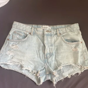 Ljusa jeansshorts från Pull&Bear - Säljer ett par ljusa jeansshorts från Pull&Bear med slitna detaljer och fransar. Perfekt för sommaren! Kontakta vid intresse! ❤️