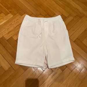 Vita shorts från Zara - Snygga vita shorts från Zara med snörning i midjan. Perfekta för en avslappnad stil. De har en enkel design med fickor både fram och bak. Knappt änvänd, köpte i slutet på förra sommaren. Säljer även matchande topp i min profil.