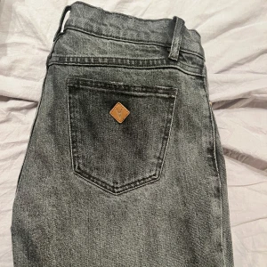 Grå jeans från Abrand - Snygga grå jeans från Abrand med en klassisk femficksdesign. De har en knappgylf och en liten logga på bakfickan. Perfekta för en avslappnad stil.