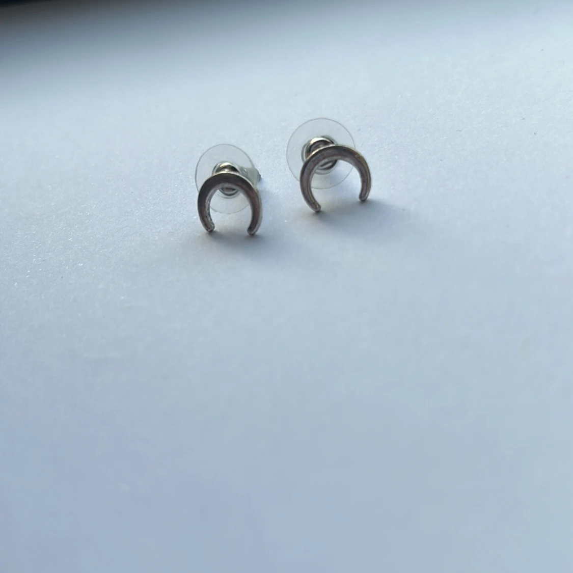 Silverfärgade örhängen i halvmåneform