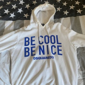 Vit hoodie från DSQUARED2 - Säljer en vit hoodie från DSQUARED2 med texten 'BE COOL BE NICE' i blått på framsidan. Hoodien är köpt för cirka 2 år sen och endast använd fåtalet gånger. Har mest legat i garderoben sedan dess. Skick 8/10. Nypris cirka 3500kr.