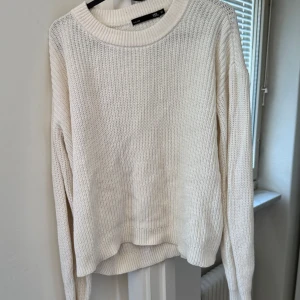 Vit stickad tröja från 157 - Säljer en stilren vit stickad tröja från 157. Tröjan har en klassisk rund halsringning och långa ärmar, perfekt för kyligare dagar. Den är mjuk och bekväm, idealisk för en avslappnad look. Passar bra till jeans eller kjol.