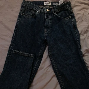 Mörkblå jeans från Pull&Bear - Säljer ett par mörkblå jeans från Pull&Bear. De har en klassisk femficksdesign med knapp och dragkedja framtill. 