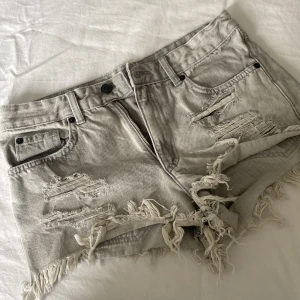 gråa jeansshorts - Säljer ett par grå jeansshorts med slitna detaljer och fransar. Shortsen har en knapp och dragkedja framtill samt fem fickor. Säljer pågrund av dem är för små. !!är inte stretchiga! Kontakta för mer info❤️