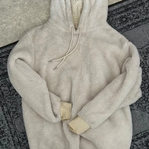 Beige fleece hoodie - Mysig beige hoodie i fleece med luva och dragsko. Perfekt för kalla dagar när du vill hålla dig varm och bekväm, eller sen sommarkväll. Den har långa ärmar och ribbade muddar vid ärmslut. Lika lurvigt och mjukt material inuti. 💌