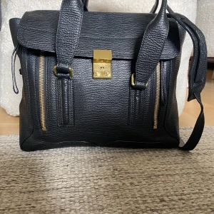 3.1 Phillip Lim pashli medium satchel - Fint skick. Repor på lås och metalldelar. Mindre obetydliga märken på lädret. Ren och fräsch på insida. Dustbag ingår. Köpt på Vesteria så inga original kvitton