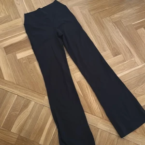 Svarta byxor från H&M Move - Snygga svarta byxor från H&M Move med hög midja och bootcut-stil. Perfekta för en stilren look. Tillverkade i ett bekvämt material som ger en skön passform. Säljer dem för att jag har flera som är likanande, endast testade🥰aldrig använda 