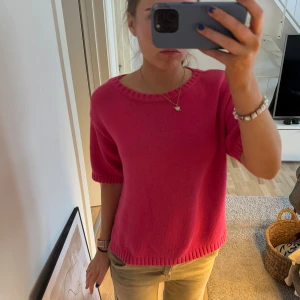 Rosa stickad tröja från Panache - Säljer en snygg rosa stickad tröja från Panache. Tröjan har en rund halsringning och korta ärmar, perfekt för en avslappnad stil. Den är mjuk och bekväm, idealisk för både vår och sommar. Passar bra till jeans eller kjol för en trendig look.