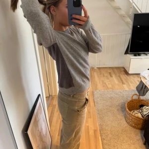 Grå kashmir cashmere tröja från Uniqlo - Säljer en stilren grå långärmad tröja med rund hals. Perfekt för en avslappnad look. Tröjan har en normal passform och är tillverkad i ett mjukt material som känns skönt mot huden.