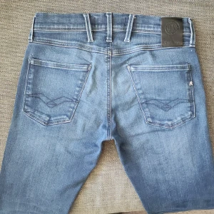 Replay Anbass hyperflex  - Tjena, säljer nu ett snygga par Replay Anbass slim fit jeans. Jeansen är i jättefint skick (10/10) och har inga tecken på användning. Dom är i storlek W28 L32. Notera att jeansen är ljusare på bilden än i verkligheten. Dom är köpta för 1100kr men säljer bara för 499! Tveka inte att kontakta mig vid frågor. 