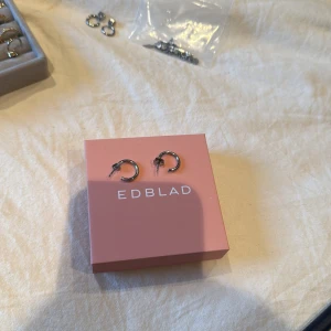 Silverörhängen från Edblad - Snygga och stilrena silverörhängen från Edblad. Perfekta för att ge en elegant touch till din outfit. Kommer i en fin rosa förpackning.