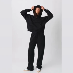Gina tricot - mjukis set - svart - Säljer en stilren svart hoodie med en bekväm passform. Tröjan har en klassisk design med huva och en stor ficka framtill. Perfekt för en avslappnad look.
