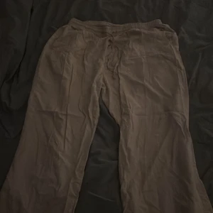 Bruna mjukisbyxor med snörning - Bekväma bruna mjukisbyxor med snörning i midjan. Perfekta för en avslappnad dag hemma eller en lugn promenad. Byxorna har en loose passform och är tillverkade i ett mjukt material.