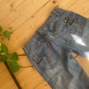 Blå jeansbyxor från K&M Jeans - Snygga blå jeansbyxor från K&M Jeans med klassisk femficksdesign och dekorativa sömmar på bakfickorna. Byxorna har en normal passform och är tillverkade i jeansmaterial. Perfekta för en avslappnad stil. Ett band har gått av, se på sista bilden 🩷