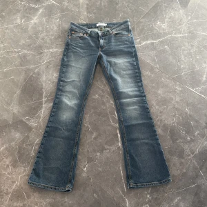 Blå lågmidjade bootcut jeans - Snygga blå bootcut jeans med lätt slitna detaljer. Använda väldigt få gånger och är som nya.💗
