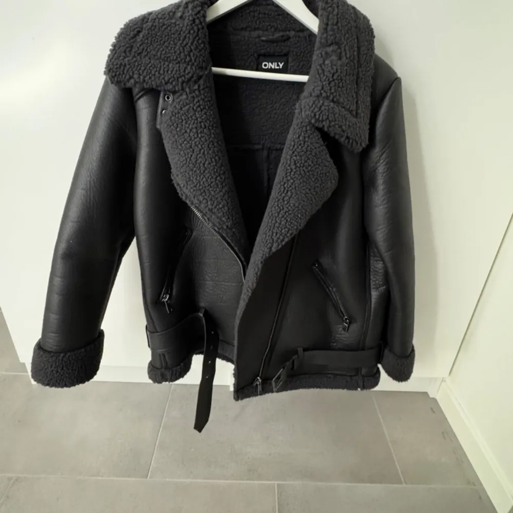 Snygg svart jacka från ONLY med fuskpälsfoder och krage. Jackan har dragkedja och bälte i midjan för en cool look. Använt en gång.. Takit.