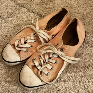 Beige sneakers från Converse - Säljer ett par klassiska beige Converse All Star sneakers med snörning och rund tå. Skorna har en textil ovandel och är perfekta för en avslappnad stil. De är i storlek dam 37,5. 