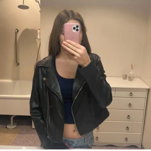 Svart skinnjacka från Vero Moda - Snygg svart skinnjacka från Vero Moda i storlek S. Jackan har en klassisk bikerstil med dragkedja och knappar. Perfekt för en cool och stilren look. Knappt använd använt kanske 4 ggr. Passar xs, bra skick 