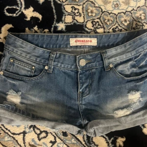 Blå lågmidjade jeansshorts  - Supersnygga blå lågmidjade jeansshorts med slitningar på låren! Köpta utomlands i en second hand butik, står storlek 40 men passar en S ❤️ inga defekter utöver vad som syns på bilderna!