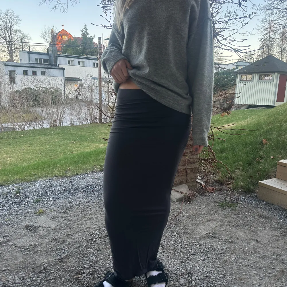 Snygg mörk grå långkjol från Gina Tricot i en tight passform. Kjolen är perfekt för en stilren look och kan enkelt matchas med olika toppar. Den har en enkel design utan mönster eller extra detaljer. Pris kan diskuteras. Hameet.