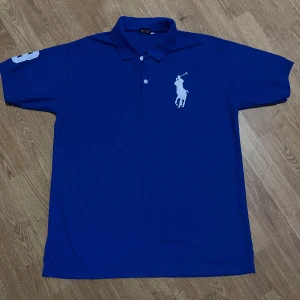 Blå pikétröja - Fet blå pikétröja i storlek L. Helt ny. Tyvärr inte äkta men riktigt fet ändå