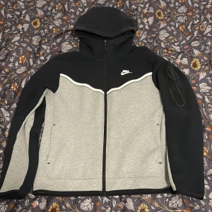 Svart och grå hoodie från Nike - Säljer min Nike tech. Skick 8/10 ny pris 1200 köpt från Zalando.