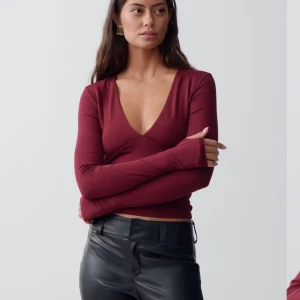 Vinröd v-ringad topp från Gina Tricot - Säljer en stilren vinröd topp från Gina Tricot med v-ringning och långa ärmar. Helt ny! Storlek xs