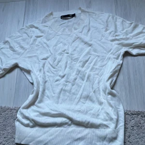 Vit tröja från 157 - Säljer en stilren vit tröja från 157. Tröjan har en rund halsringning och ribbade kanter vid ärmslut och nederkant. Perfekt för en enkel och klassisk look.