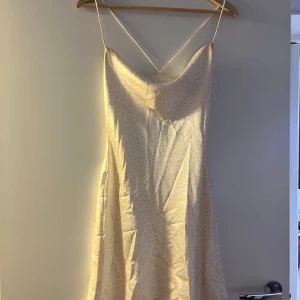 Vit blommig klänning från NA-KD - Säljer en söt vit klänning från NA-KD med små gula blommor. 