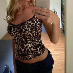 Leopardmönstrad topp - Trendig leopardmönstrad topp med korta ärmar och en smickrande passform. Perfekt för att ge din outfit en djärv touch. Använd 3-5 gånger! ❤️