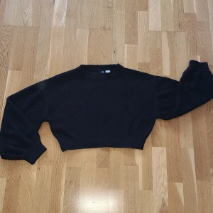 Svart stickad tröja från H&M Divided - Säljer en svart stickad tröja från H&M Divided. Tröjan har en croppad design med långa ärmar. Pris kan diskuteras vid snabb affär