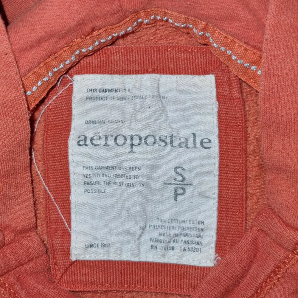 Säljer en snygg orange hoodie från Aeropostale med tryck framtill. Tröjan har en klassisk huva och långa ärmar, perfekt för en avslappnad stil.. Hupparit & Collegepaidat.