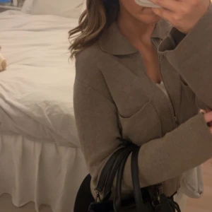 Brun/beige kofta med dragkedja - Säljer en stilren brun/beige kofta med dragkedja och krage. Jackan har långa ärmar och två framfickor. Perfekt för att styla med! Nypris 599 och mitt pris 250, koftan är i mycket bra skick och har användts fåtal gånger! 💗