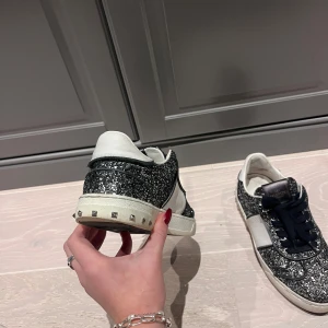 Glittriga sneakers från Valentino - Säljer mina älskade valentino skor, vänster skon har alla taggar kvar och är i jätte bra skick, höger skon har tyvärr tappat tre taggar och tråden till sulan har gått upp. Storlek 36 men de är stora i storleken, passar mig som har 37 i vanliga fall❣️