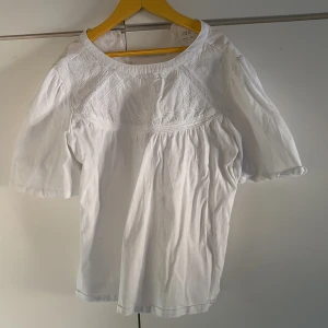 Vit blus från Zara - Säljer en söt vit blus från Zara med vackra broderade detaljer och korta ärmar. Perfekt för en stilren och elegant look. Blusen har en rund hals och är tillverkad i ett lätt och bekvämt material. Tröjan är använd en gång på en skolavslutning och kommer inte längre till användning 🥰