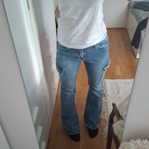 Blå bootcut jeans med fickor - Blå bootcut byxor med två fickor på sidan. Storlek 170, mycket bra skick använda 3 gånger, lite slitna på änden av ena benet