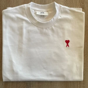 Ami Paris T-shirt - Säljer nu denna perfekta sommar t-shirten från Ami Paris då jag växt ur den. Passar perfekt för storlek M och skicket är så gott som nytt! Pris:699| Tröjan skickas samma dag! Tveka inte på att fråga/skriva vid intresse!