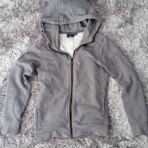 Grå hoodie från Sail Racing - Säljer en grå hoodie från Sail Racing med dragkedja och justerbar huva. Tröjan har ett märke på ärmen med texten 'Antarctica Expedition'. Storlek 150💕 pris kan diskuteras 💕😉