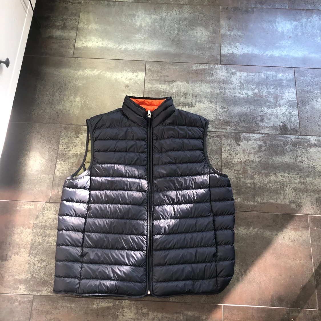 Svart dunväst med orange foder