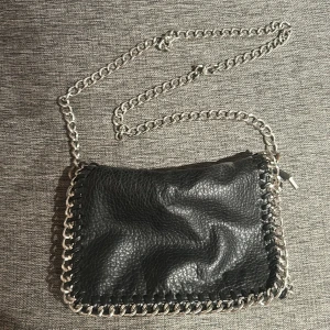 Svart axelväska med kedjedetaljer - Fin väska från Tiamo. Bra skick! 