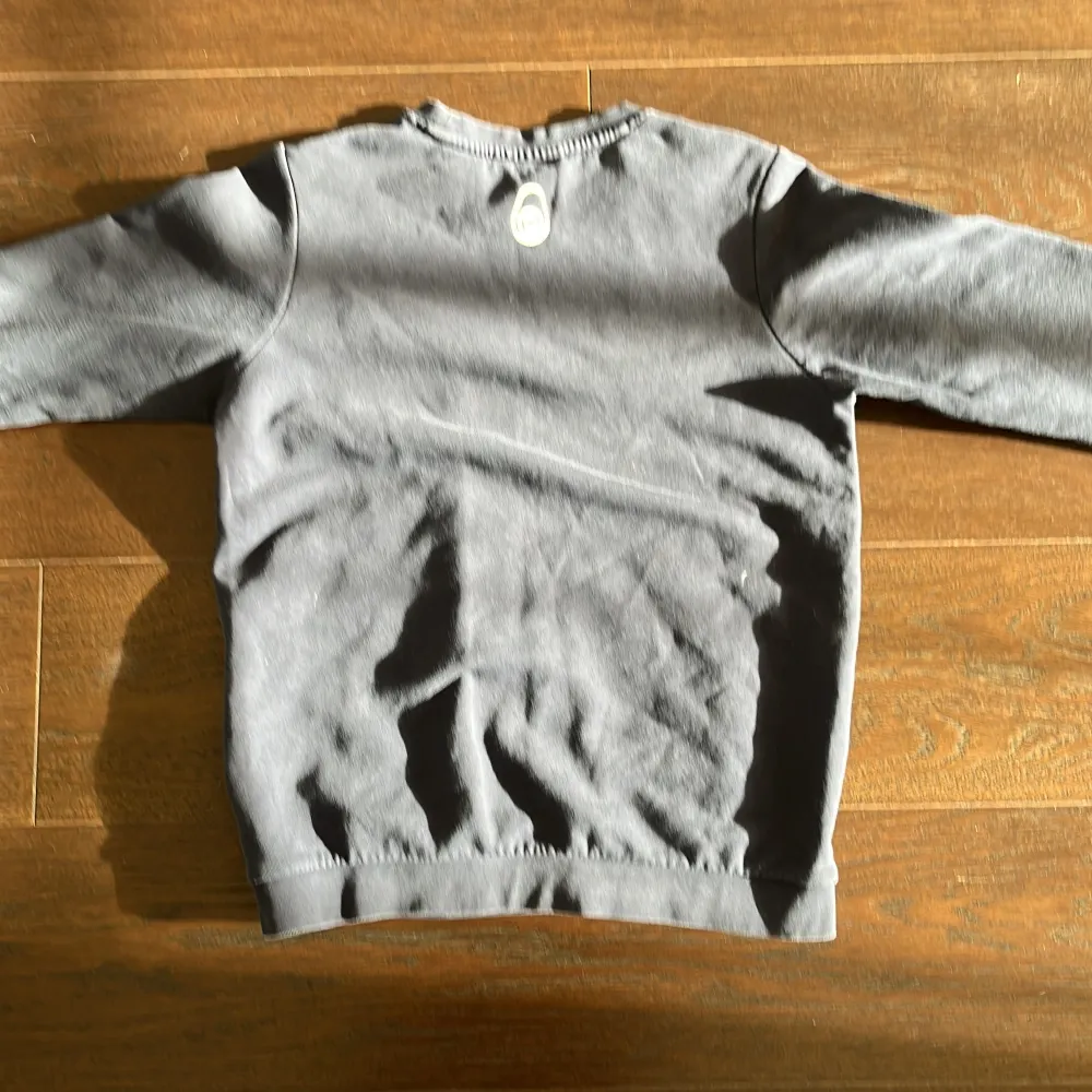 Säljer en stilren blå sweatshirt från Sail Racing med tryckt logga på bröstet. Tröjan har rund hals och långa ärmar, perfekt för en avslappnad stil. Passar bra till jeans. Storlek 160. Bra skick . Neuletakit & Villapaidat.