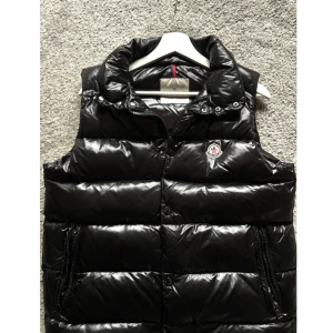 Moncler svart dunväst  - Snygg svart dunväst från Moncler med glansig finish och klassisk logga på bröstet. Storlek S men passar M. Detta är ej äkta (men) den ser precis ut som en äkta, samt QR koden tar dig direkt till Monclers hemsida. 