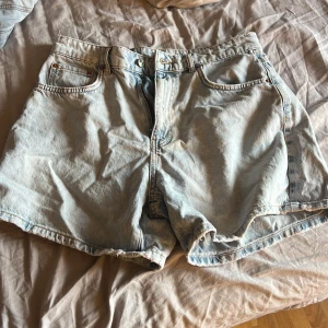 Ljusblå jeansshorts från gina tricot perfect jeans - Ljusblå jeansshorts med klassisk femficksdesign och rå kant nertill. Modellen är loose fit och har dragkedja och knapp framtill. Perfekta för sommaren och lätta att matcha med allt. Går att rulla upp nere om man vill!!