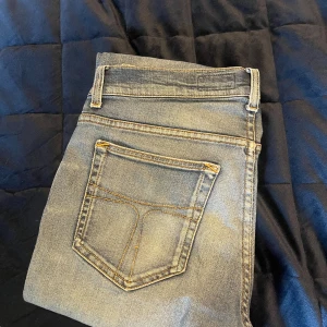 Tiger of sweden jeans - Snygga ljusblå jeans med stright passform och klassiska fickor. Jeansen har slitna detaljer och en tvättad look, perfekt för en avslappnad stil. Tillverkade i stretchigt jeanstyg för extra komfort och rörelsefrihet.