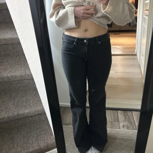 Svarta lågmidjade bootcut jeans - Snygga svarta jeans med bootcut-modell och låg midja. Jeansen har klassisk femficksdesign och stängs med knapp och dragkedja. Perfekta för dig som gillar en tidlös och trendig look.🩷Strl: 42 men passar bäst M🩷